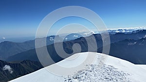 A breathtaking view from the top of Mount Kazbek. A panorama of impregnable snow-capped mountains