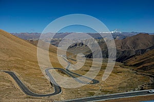 Breathtaking view of a winding mountain road leading across the Tibetan Plateau.