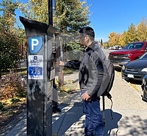 Tourist trying to pay his parking via parking ticket kiosk