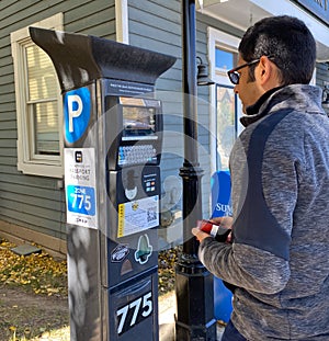 Tourist trying to pay his parking via parking ticket kiosk