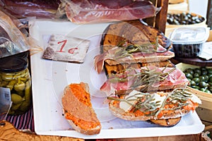 Bred with olive oil pa amb oli with jamon, sobrasada and Majorcan herbs for sale at Sineu market, Majorca photo