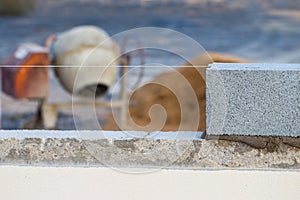 Breeze block wall construction with string line and cement mixer