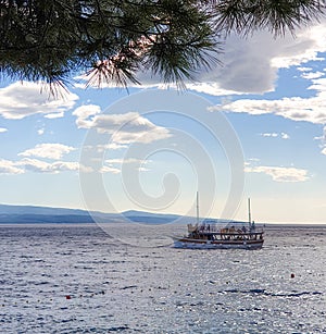 Brela, Croatia - June 24, 2019: A pleasure boat sails into the sea for a tour of the islands on a sunny summer day