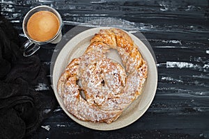 Bretzel with sugar and yolk cream on white dish