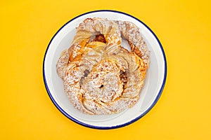 Bretzel with sugar and yolk cream on white dish