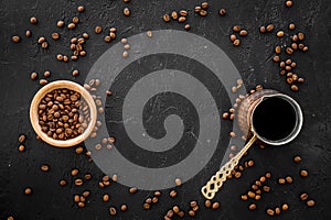 Brew coffee in turkish coffee pot. Black background top view copyspace