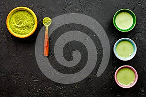 Brew matcha tea. Bowl with powder and cups with beverage on black background top view copy space