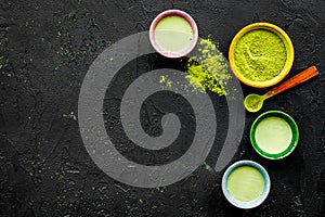 Brew matcha tea. Bowl with powder and cups with beverage on black background top view copy space