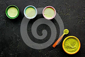 Brew matcha tea. Bowl with powder and cups with beverage on black background top view copy space