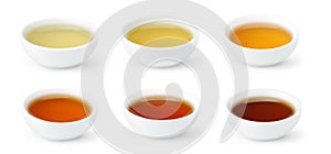 Brewed Chinese teas of different color in white bowls isolated on white background