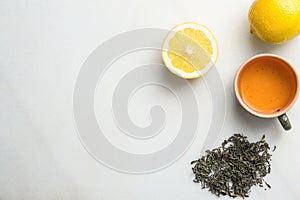 Brewed Green Tea in Ceramic Cup. Loose Leaves Scattered on White Marble Stone Background Slice of Lemon. Chinese Japanese