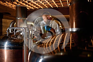 Brewer adding ferment with yeast or hop into beer tank