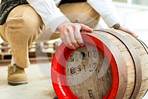 Brewer with beer barrel in brewery