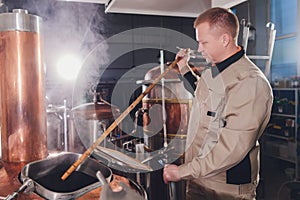 Brewer in brewhouse pouring out the malt to the tank.