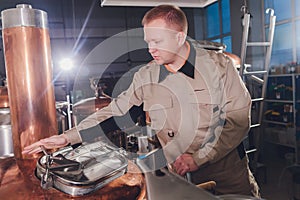 Brewer in brewhouse pouring out the malt to the tank.