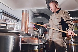 Brewer in brewhouse pouring out the malt to the tank.