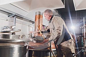 Brewer in brewhouse pouring out the malt to the tank.