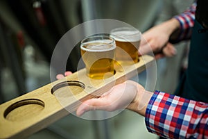 Brewer holding beer sampler tray