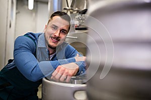 Brewer leaning on keg