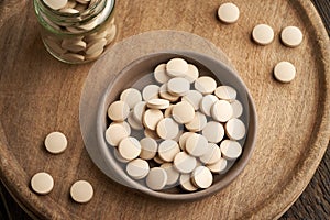 Brewer`s yeast tablets in a bowl, top view
