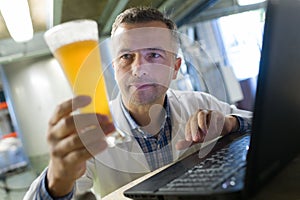 Brewer in uniform tasting beer