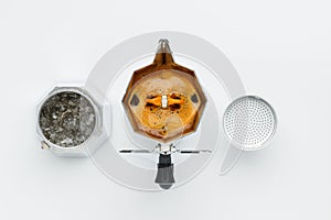 Brewing coffee in a coffee maker top view on a white background.