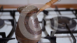 Brewing Ground Turkish Coffee in a Copper Turk on a Gas Stove. Slow motion