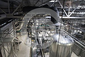Brewing production, workshop with steel tanks, pipes and machinery at modern beer factory