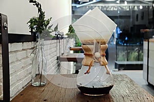 Brewing third wave coffee with chemex glass on wooden table