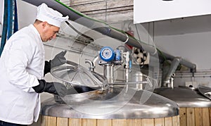 Brewmaster opening lid of fermenter while checking beer production process