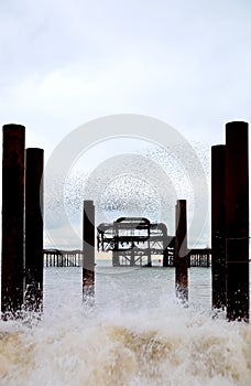 Brghton West Pier, rough sea, crashing wave, starlings flying above