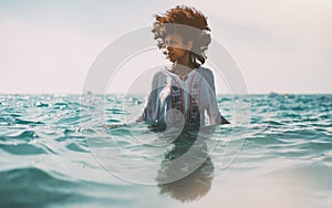 Briacial girl standing waist-deep in sea water