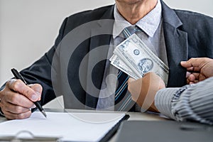 Bribery and corruption concept, bribe in the form of dollar bills, consultant receive money from businessman while making deal to