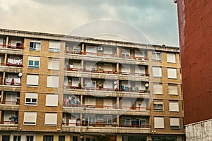 Brick apartment building with balconies and drying laundry photo