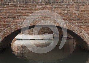 Brick bridge in sight and its arch reflecting on the underlying