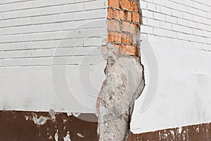 Brick brown red broken masonry wall with cement white concrete damaged facade background texture old