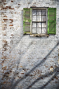 brick building with rectangular green wooden shuttered windows