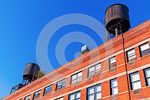 Brick building with typical water tanks on the roof in NYC