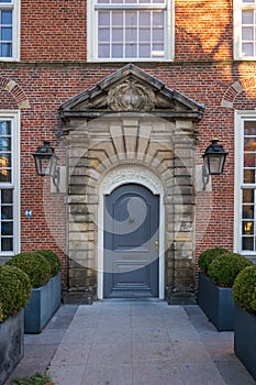 A brick-built house facade with a stone-made carriage porch