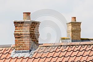 Brick chimney stack on modern contemporary house roof top