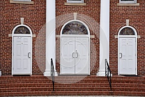 Brick church with three white doors