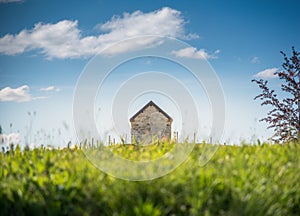 A brick cottage among an evening meadow