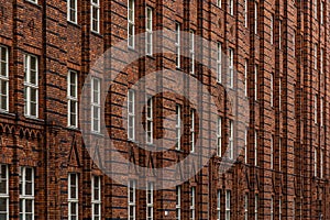 Brick facade with rhythmic windows and decorative masonry. Modular pattern.