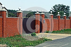 Brick fence with lanterns and gates in the street