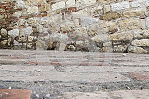 Brick floor beside old white wall