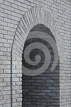 Brick gray wall with a semicircular arch entrance