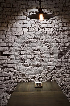 Brick grunge wall and ceiling lamp above table