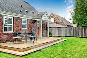 Brick house exterior with walkout wooden deck photo