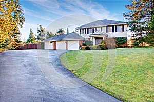 Brick house with greenery and driveway.