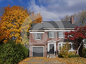 Brick house with maple tree and fall colors